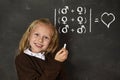 Schoolgirl in uniform holding chalk writing on blackboard standing for freedom of sexuality orientation