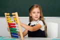 Schoolgirl in uniform practising math using abacus Royalty Free Stock Photo