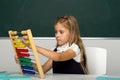 Schoolgirl in uniform practising math using abacus Royalty Free Stock Photo
