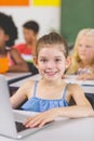 Schoolgirl using laptop in classroom