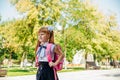 A schoolgirl in a white blouse and a black skirt with a briefcase is walking down an alley or down the street Royalty Free Stock Photo