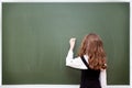Schoolgirl writes on a blackboard