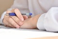 the schoolgirl& x27;s hand is holding a pen. crossword puzzle Royalty Free Stock Photo