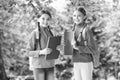 Schoolgirls with backpacks and textbooks in forest, exploring nature concept