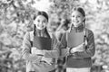Schoolgirls with backpacks and textbooks in forest, summer camp activity concept