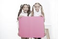 Schoolgirls hold advertisement poster copy space. Children hold advertising banner. Happy pupils children with blank Royalty Free Stock Photo