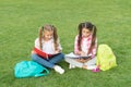 Schoolgirls little children school yard with books, interesting reading concept Royalty Free Stock Photo
