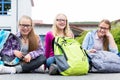 Schoolgirls sitting in schoolyard at school