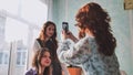 Schoolgirls taking photos of themselves on their phones in class. Royalty Free Stock Photo