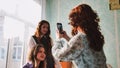 Schoolgirls taking photos of themselves on their phones in class. Royalty Free Stock Photo