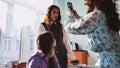 Schoolgirls taking photos of themselves on their phones in class. Royalty Free Stock Photo