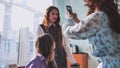 Schoolgirls taking photos of themselves on their phones in class. Royalty Free Stock Photo