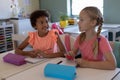 Schoolgirls talking during a lesson in an elementary school classroom Royalty Free Stock Photo