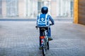 Schoolkid boy in safety helmet riding with bike in the city with backpack. Happy child in colorful clothes biking on