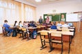 Schoolkids in the classroom sitting at their desks and listen to the teacher