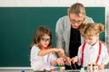 Schoolkids drawing with teacher. Children from elementary school study at draw lesson. School education and children