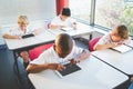 Schoolkids using digital tablets in classroom Royalty Free Stock Photo