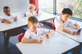 Schoolkids using mobile phone in classroom Royalty Free Stock Photo