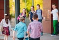 Schoolmates go to school. Students greet each other. Royalty Free Stock Photo