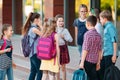 Schoolmates go to school. Students greet each other. Royalty Free Stock Photo