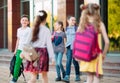 Schoolmates go to school. Students greet each other. Royalty Free Stock Photo