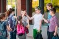 Schoolmates go to school. Students greet each other. Royalty Free Stock Photo