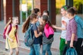 Schoolmates go to school. Students greet each other. Royalty Free Stock Photo