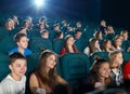 Schoolmates watching cartoon in the cinema hall.