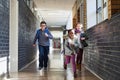 Schools out. a group of elementary school kids running in the corridor at school. Royalty Free Stock Photo