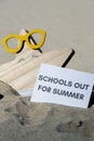 SCHOOLS OUT FOR SUMMER text on paper greeting card on background of funny starfish in glasses summer vacation decor Royalty Free Stock Photo