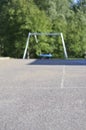 Schoolyard or playground on a sunny summer day with a blue net swing in the background as well as lush green trees. Blurry