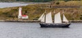 Schooner Past Small Lighthouse and Shed