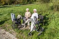 Elderly female couple enjoys the spring sun while sitting on a bench