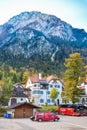 SCHWANGAU, GERMANY - OKTOBER 09, 2018: Beautiful European house and parking on background of high mountains in the Alps