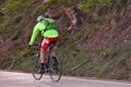 Schwarzwald, Germany - April 25 2019: Highway through the forest and a cyclist in a green jacket with a backpack and