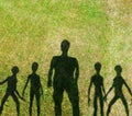 Man and extraterrestrials shadow silhouettes on grass