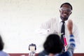 Science african teacher standing in front of blackboard teaching student in classroom Royalty Free Stock Photo