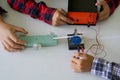 Science classroom, students are conducting a physics experiment on the speed of objects using a ticker timer device.