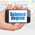 Science concept: Hand Holding Smartphone with Science Degree on display