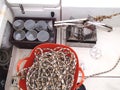 Science equipment for sea research: benthic grab, numbered plastic jars with samples, and hoisting rope on deck of the boat