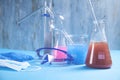 Science glassware with colored liquid, glasses, mask, gloves Royalty Free Stock Photo