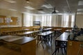 Science laboratory classroom - wooden lab tables with black countertops and sinks - windows with closed blinds - bulletin board