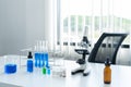 Science, laboratory tools set on the white table. microscope, tubes in the rack and blue liquid speciment Royalty Free Stock Photo