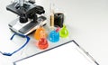 Science lecture clipboard with chemical experiment in school laboratory with beakers, microscope for testing.