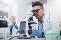 Science, microscope and innovation with a doctor man in a laboratory for research or medical development. DNA Royalty Free Stock Photo