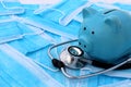 On medical masks lies a stethoscope and a piggy bank. Royalty Free Stock Photo
