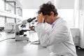 scientist with microscope working in laboratory