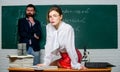 Science is sexy. Sexy girl sit table while man stand chalkboard. Flirting with colleague. Everyone dreaming about such
