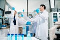 A science team joining hands in a modern laboratory, showing unity, motivation, teamwork, and collaboration while working together Royalty Free Stock Photo