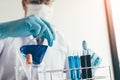 Scientific researcher or doctor pouring chemical substance test tube in laboratory